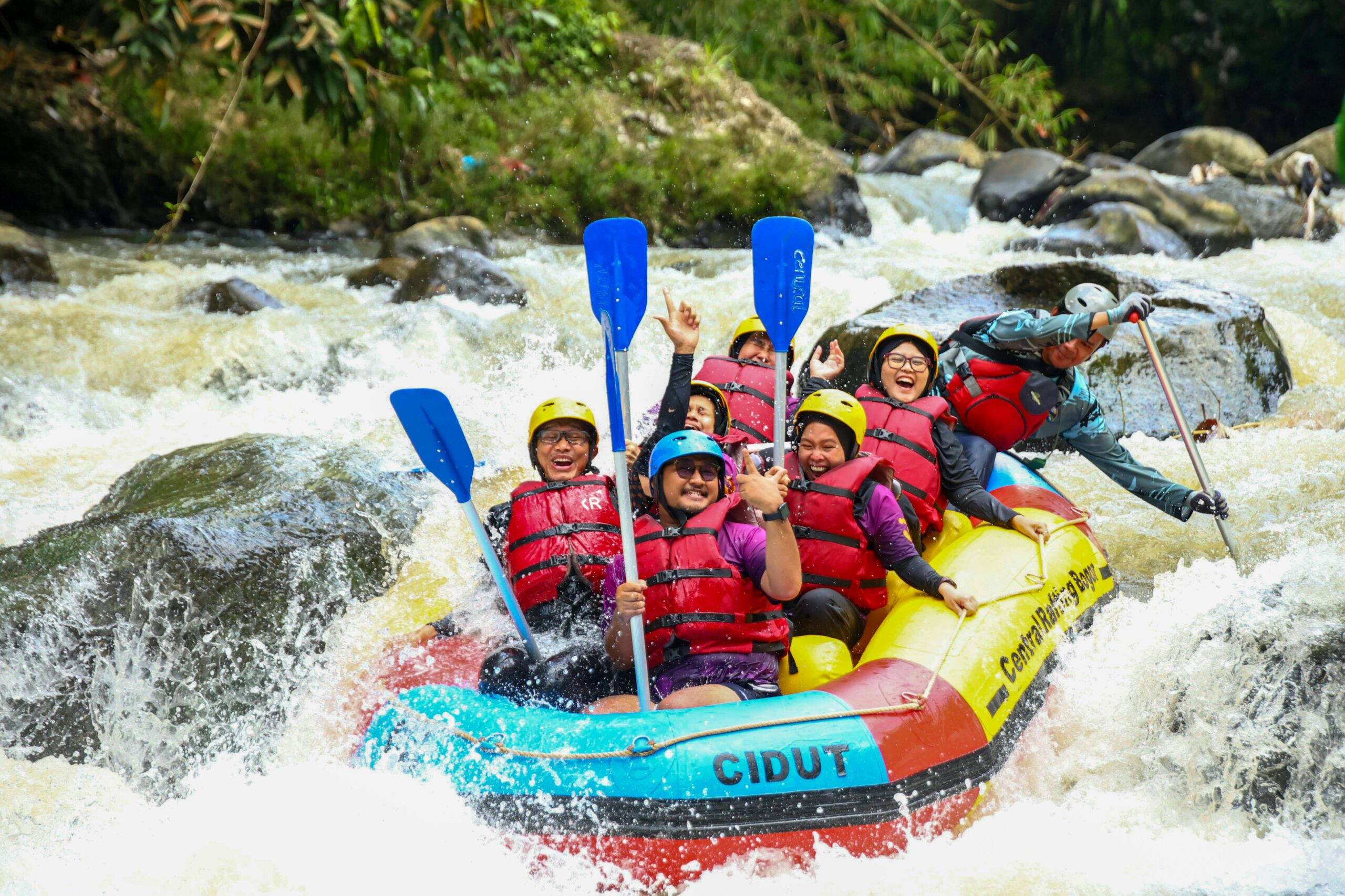 Group of thrill-seekers enjoying a whitewater rafting adventure down a river in Indonesia.