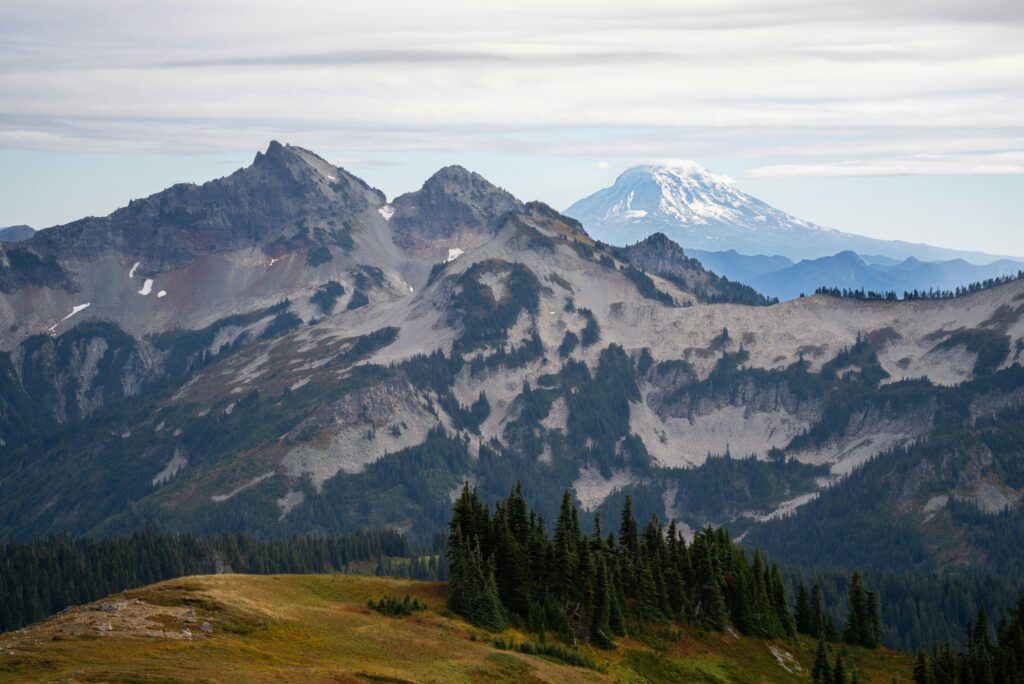 Majestic view of Mount Rainier with lush forests and rugged mountains at a national park in Washington.